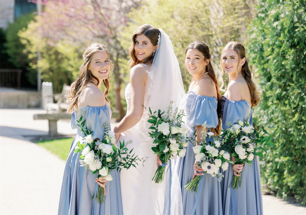 A group of beautiful girls are smiling brightly in the sun, looking forward to a wedding party.