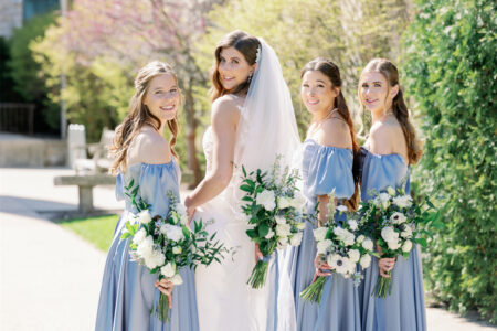 A group of beautiful girls are smiling brightly in the sun, looking forward to a wedding party.