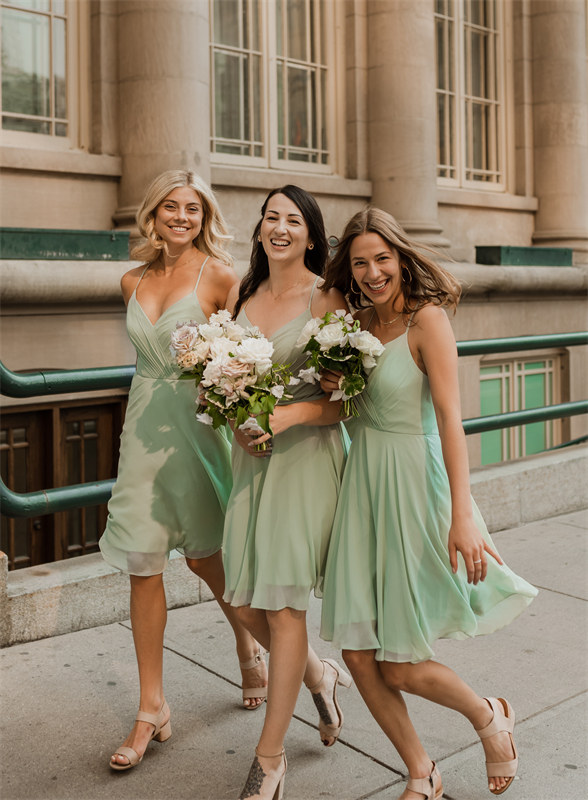 Bridesmaids in light green skirts with bouquets